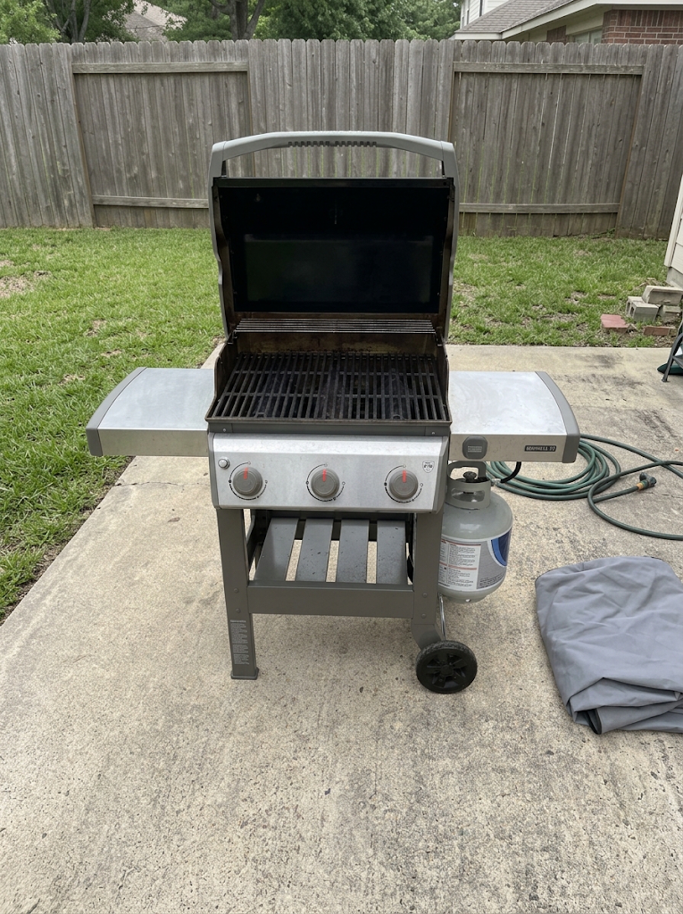 Grill on the patio, lid up, shelves out